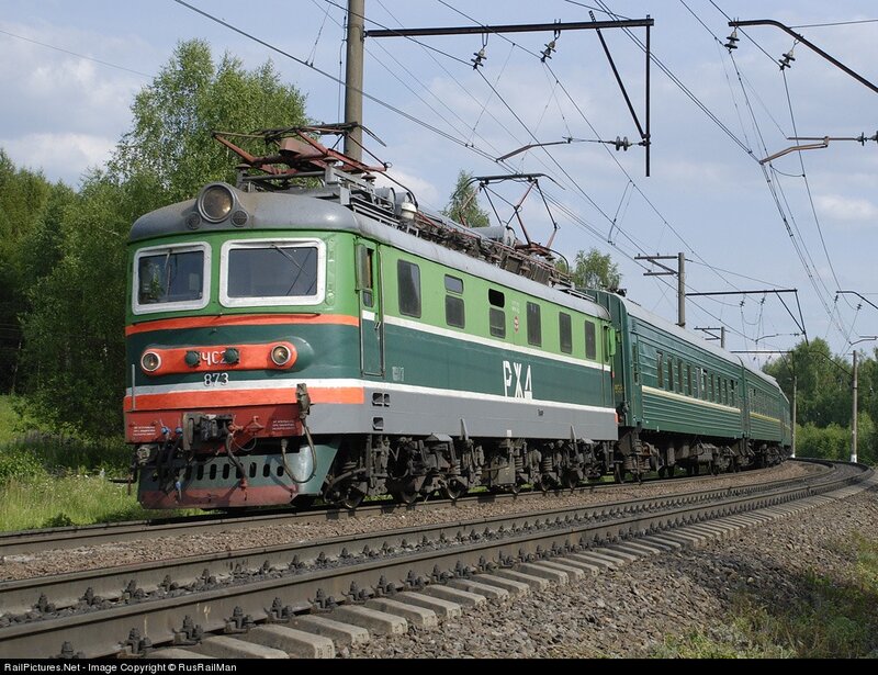 green electric locomotive on tracks