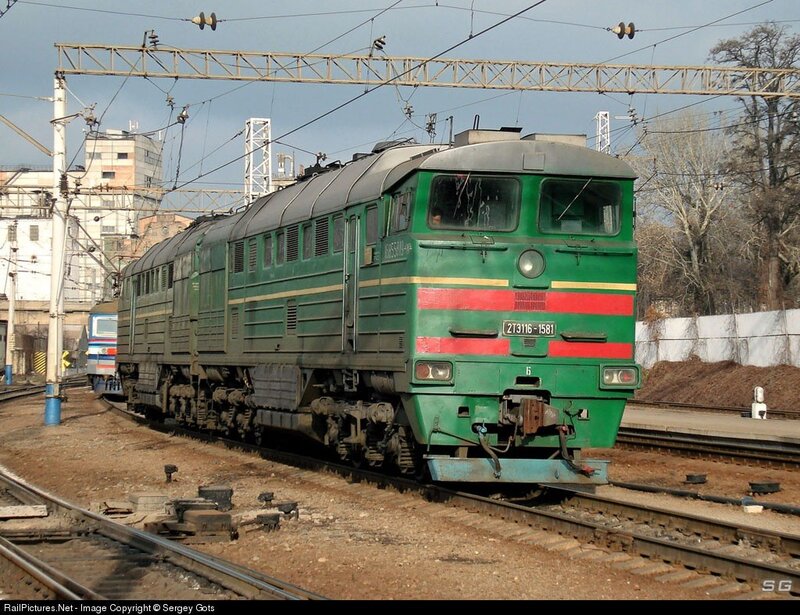 Green electric locomotive on tracks