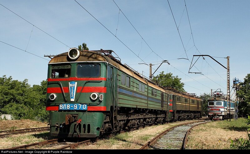 Green electric locomotive on tracks
