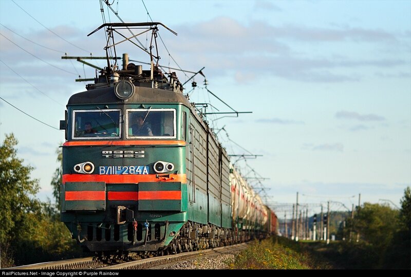Green electric locomotive on tracks
