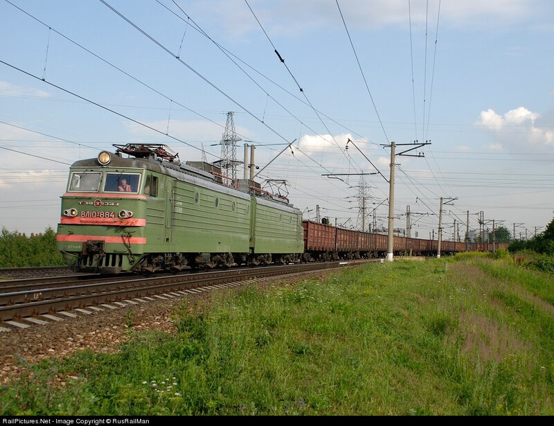 Green electric locomotive pulling freight
