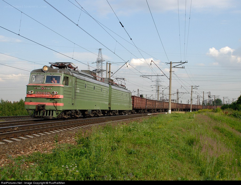 Green electric locomotive pulling freight