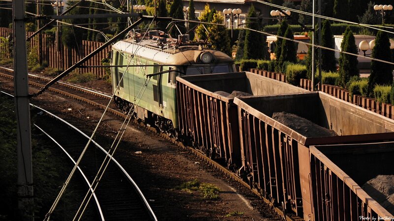 Green electric locomotive pulling freight cars
