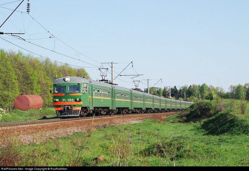 Green electric train in rural landscape