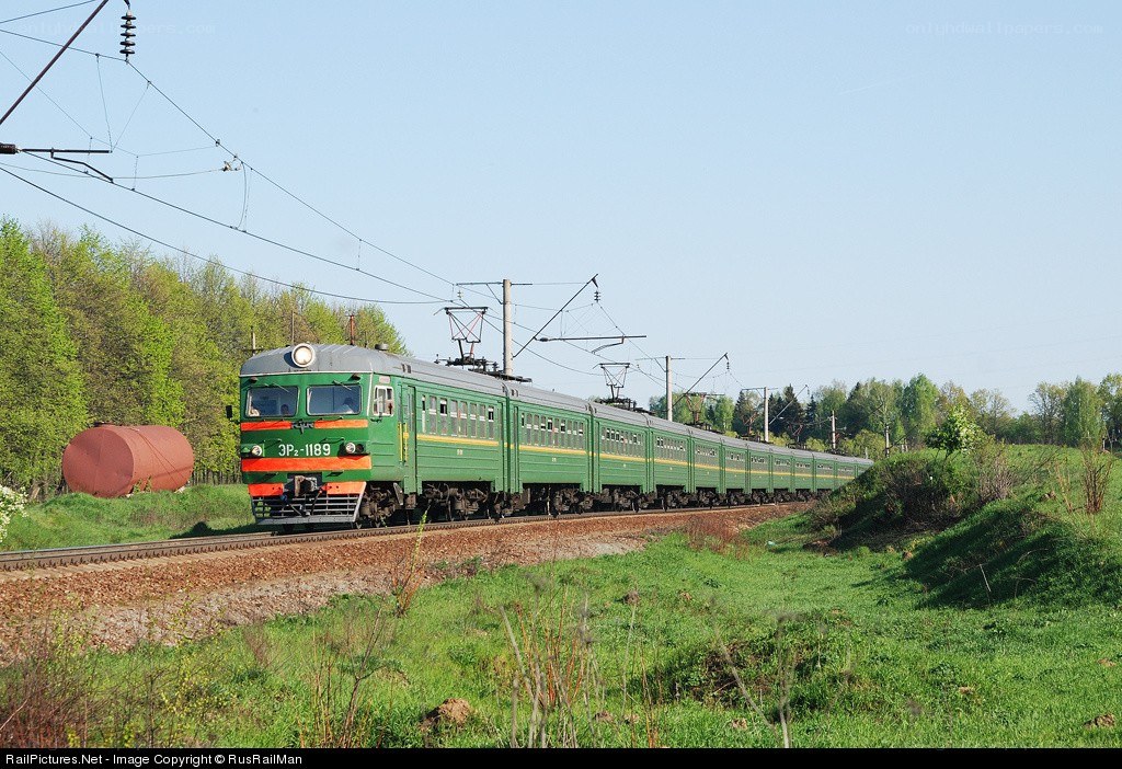 Green electric train in rural landscape