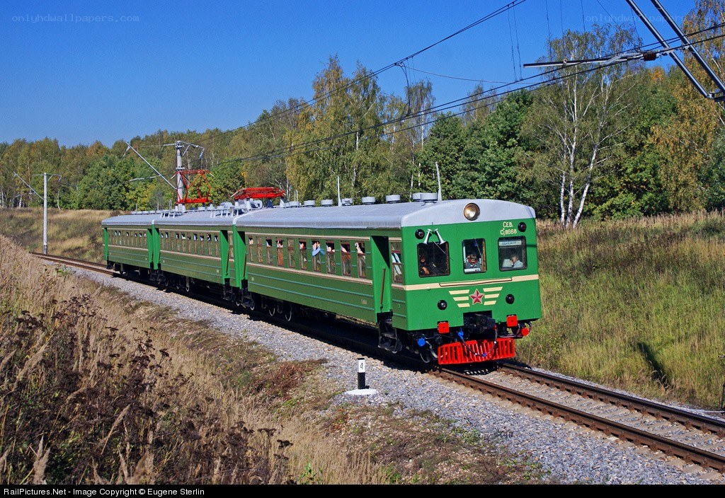 Green electric train on tracks