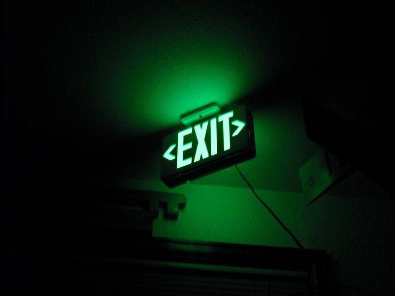 Green exit sign in dark room