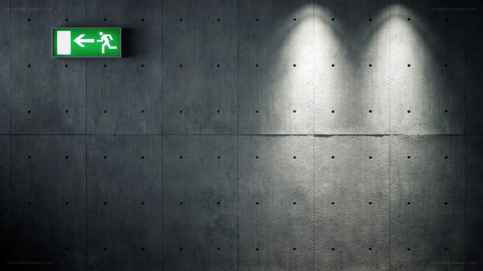 Green exit sign on concrete wall