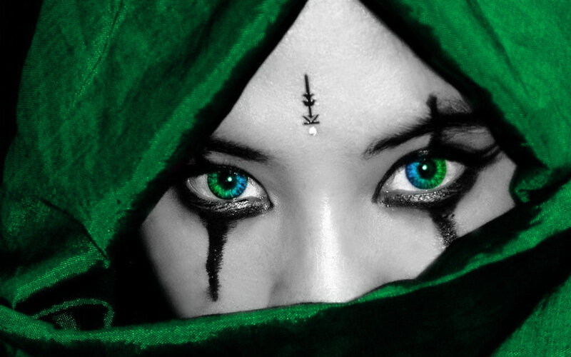 green-eyed figure in hood
