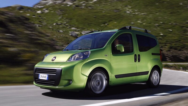 green fiat car on mountain road