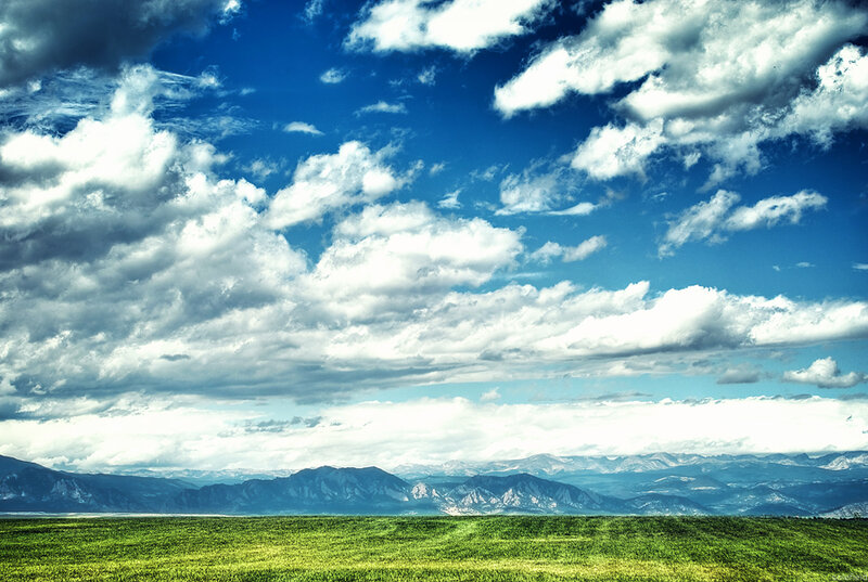 Green field under cloudy sky