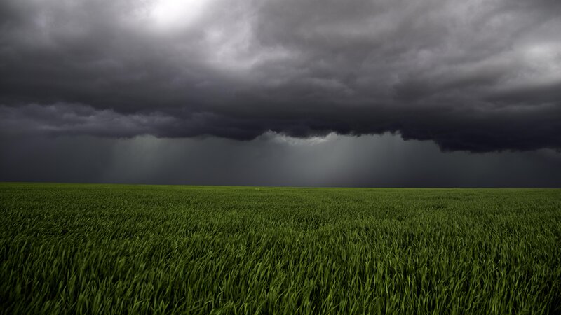 Green Field under Storm Clouds — Dramatic, Afternoon, Photograph, Storm Clouds