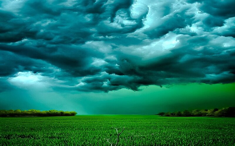 Green Field under Storm Clouds — Dramatic