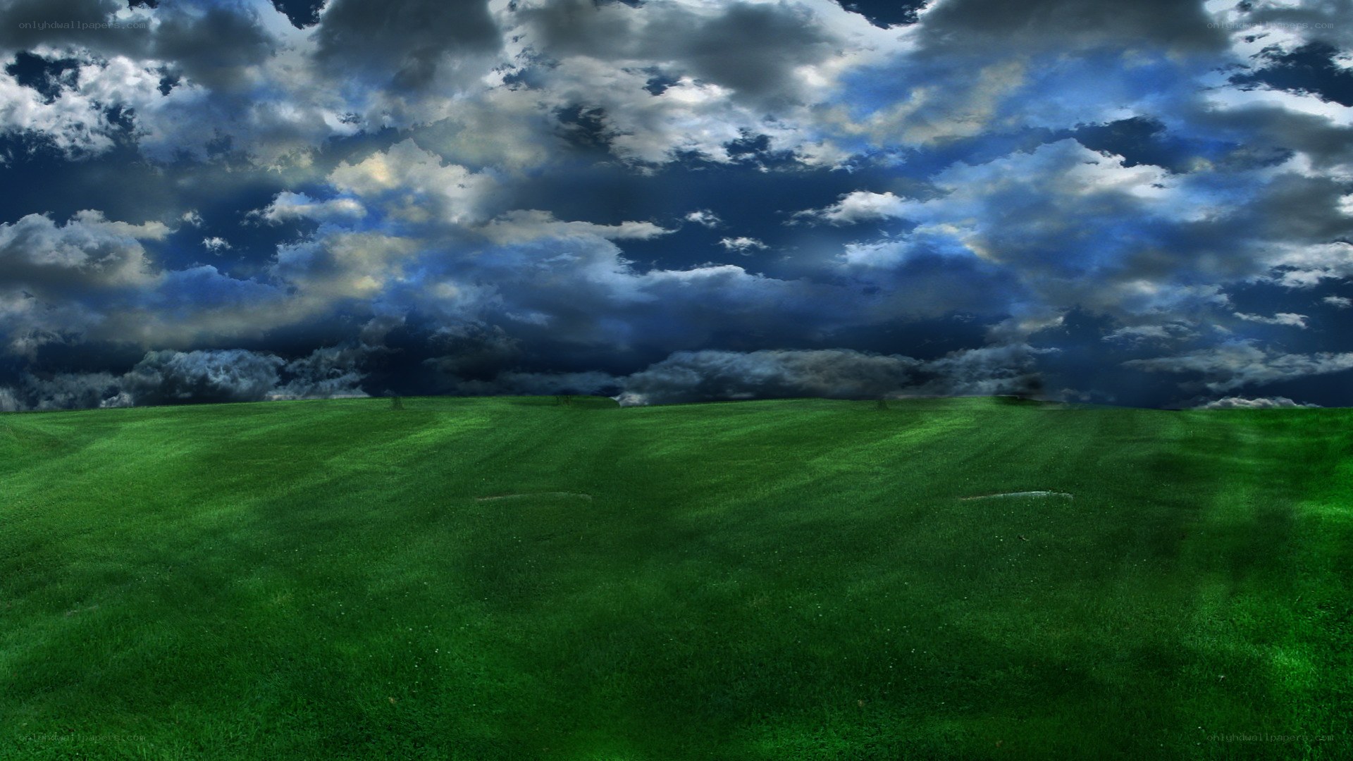 green field under stormy sky
