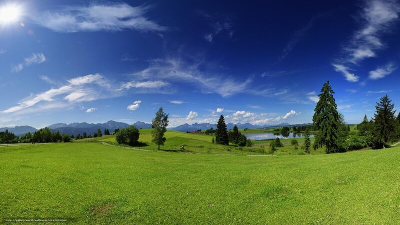 Green field with lake and mountains