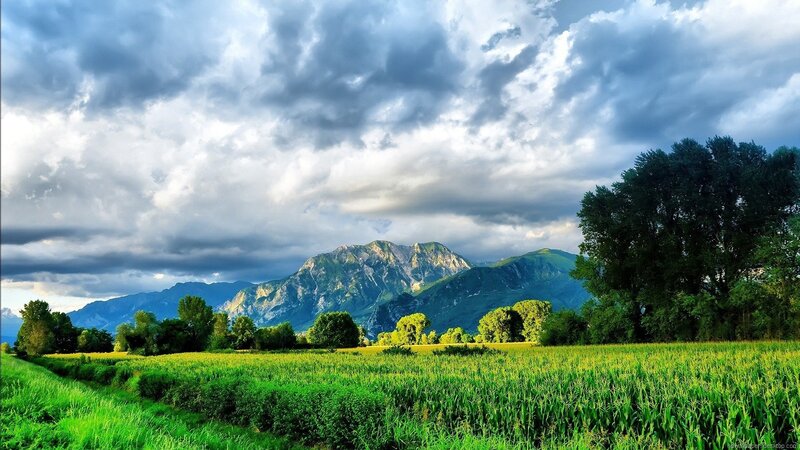 Green Field with Mountains — Dramatic, Afternoon, Photograph, Clouds