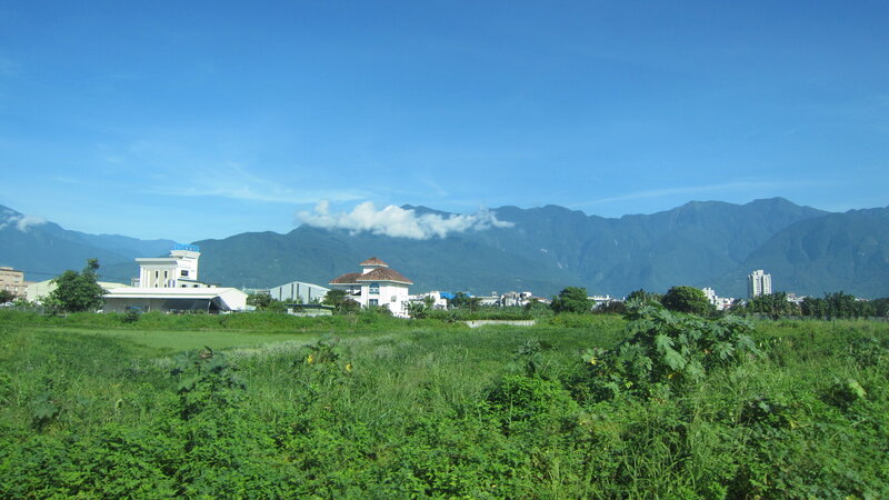 Green Field with Mountains — Serene, Afternoon, Photograph, Buildings