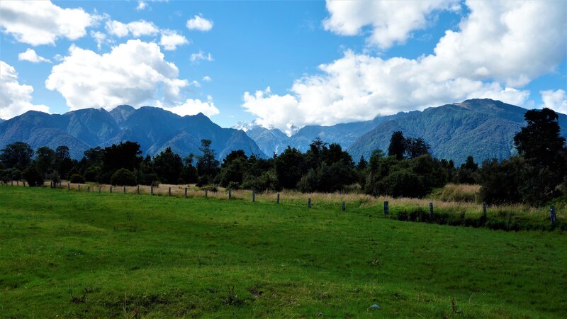 Green Field with Mountains — Serene, Afternoon, Photograph, Trees, Clouds