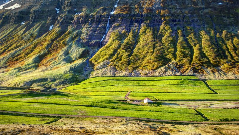 Green fields and mountain waterfall
