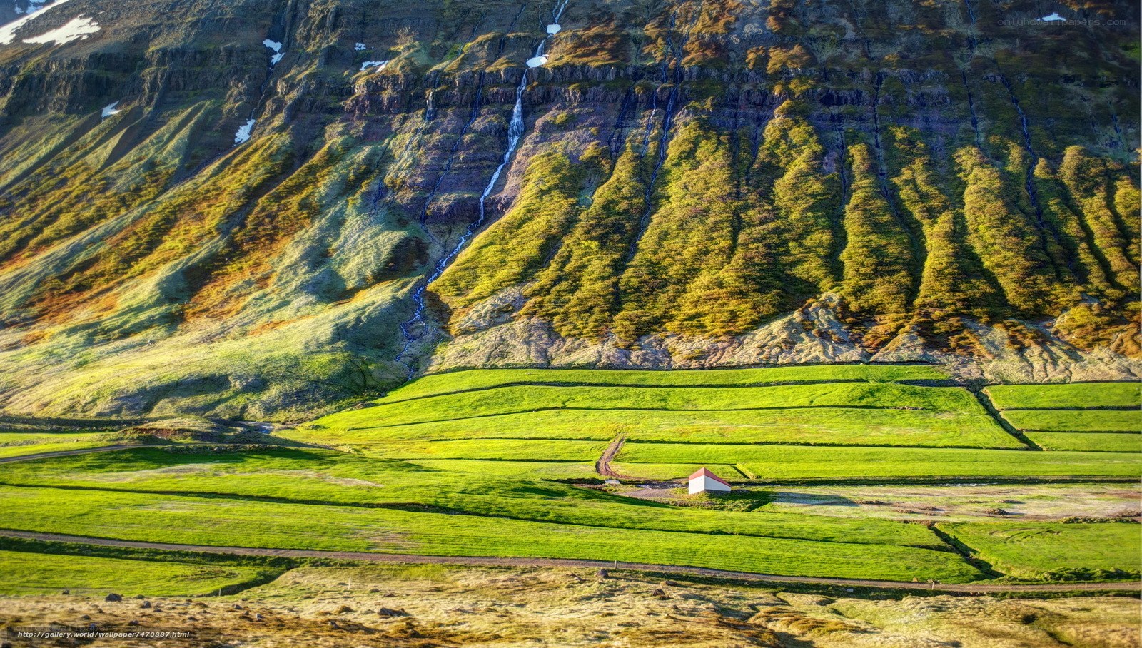 Green fields and mountain waterfall