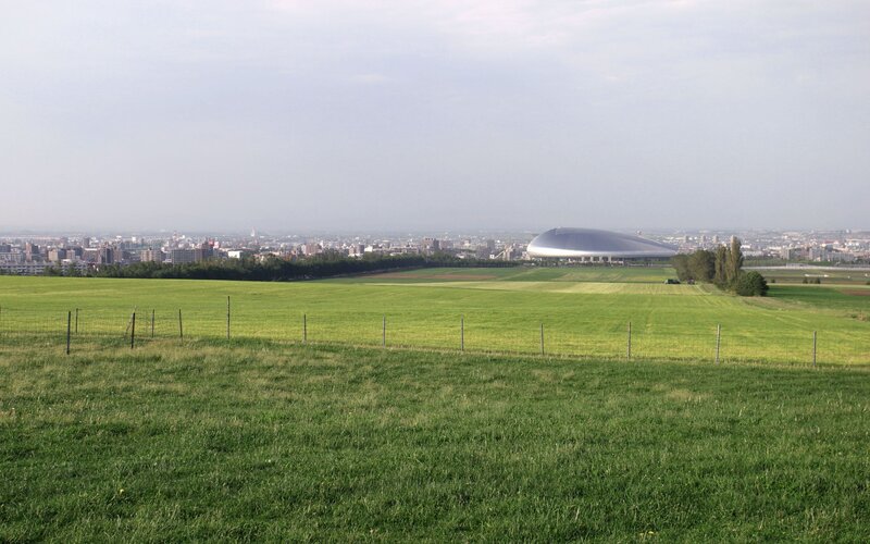 Green fields with stadium in distance
