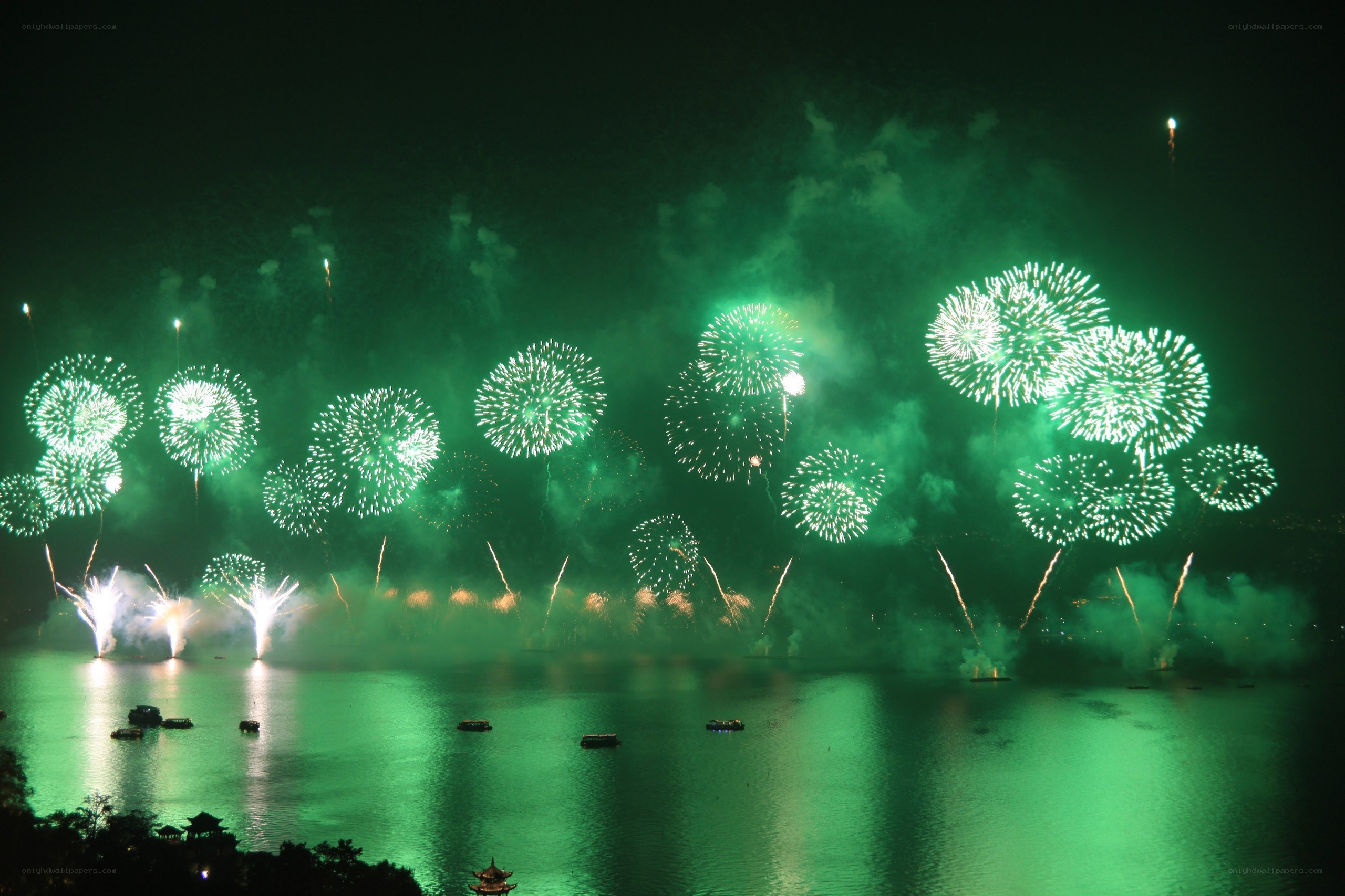 Green fireworks over a lake