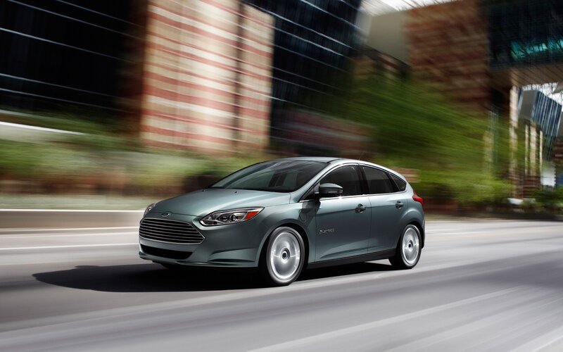 Green Ford Focus driving on city street