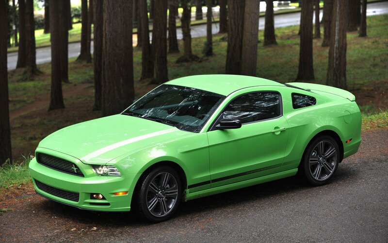 Green Ford Mustang in forest