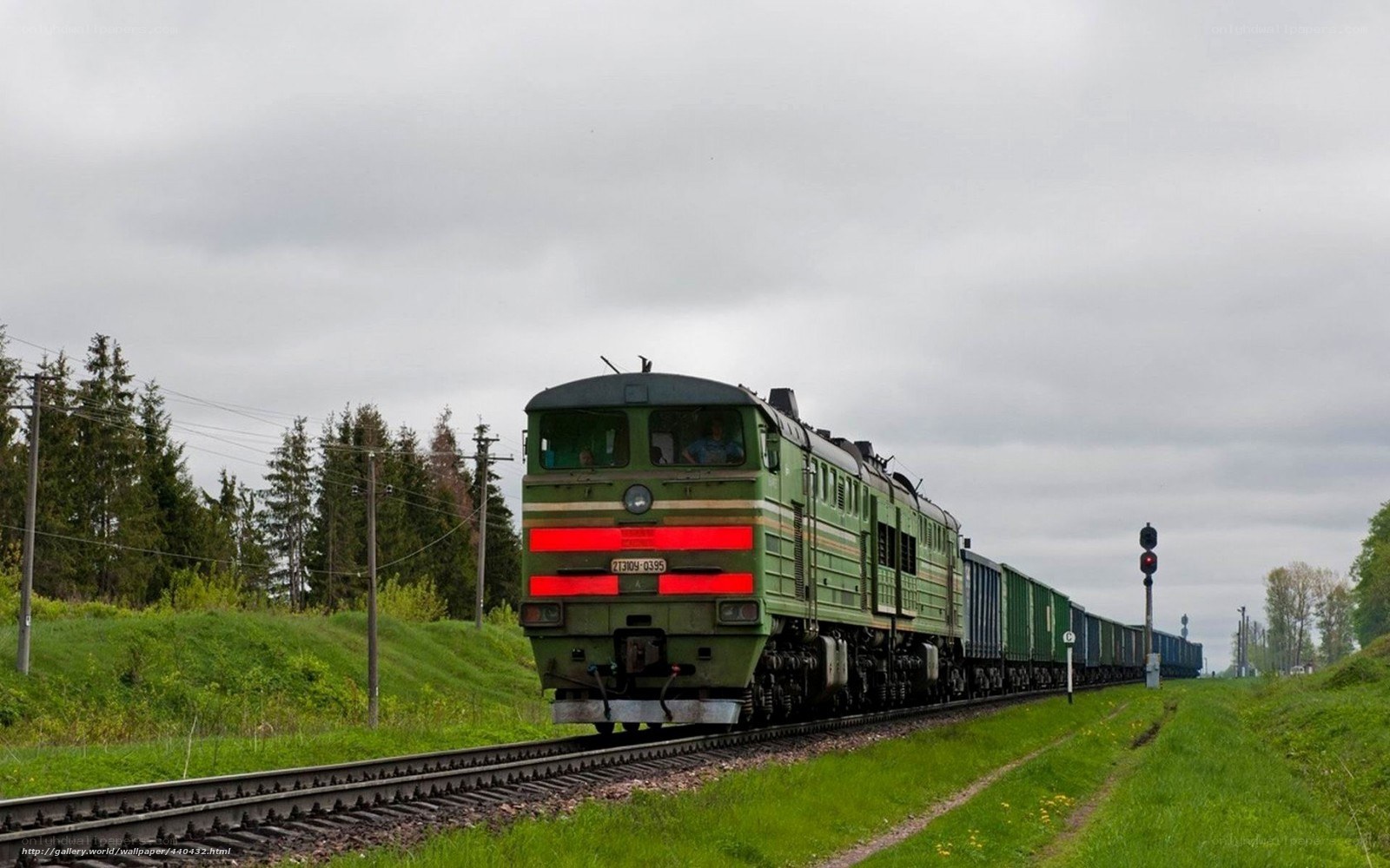 Green freight train on rural track
