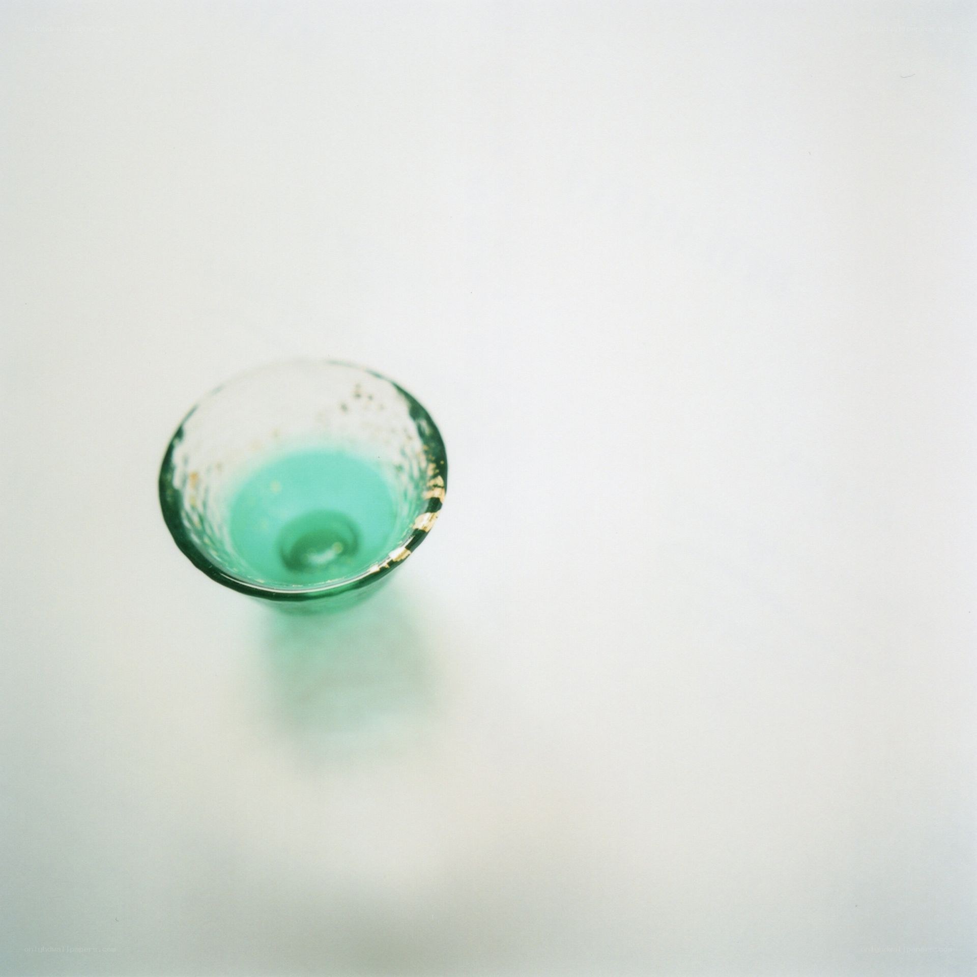 green glass cup on white surface