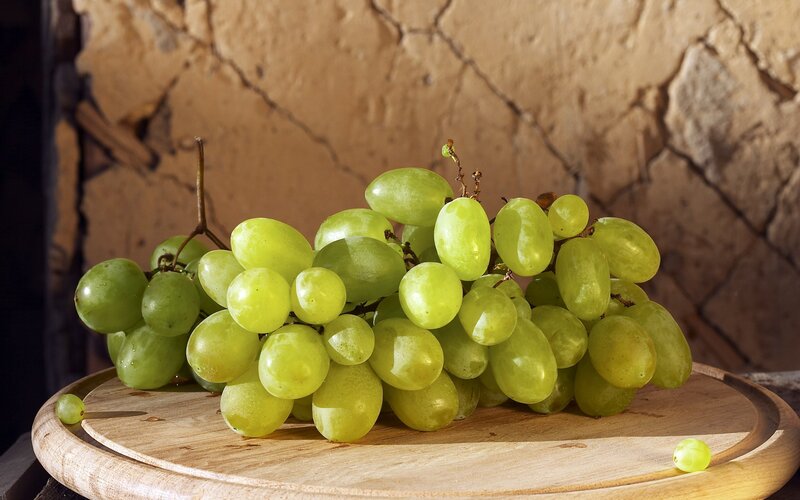green grapes on wooden board