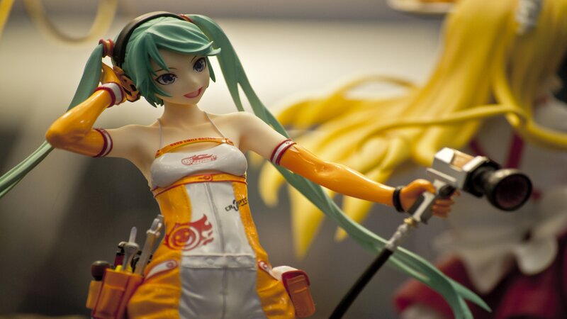 Green-haired Figurine Holding Camera