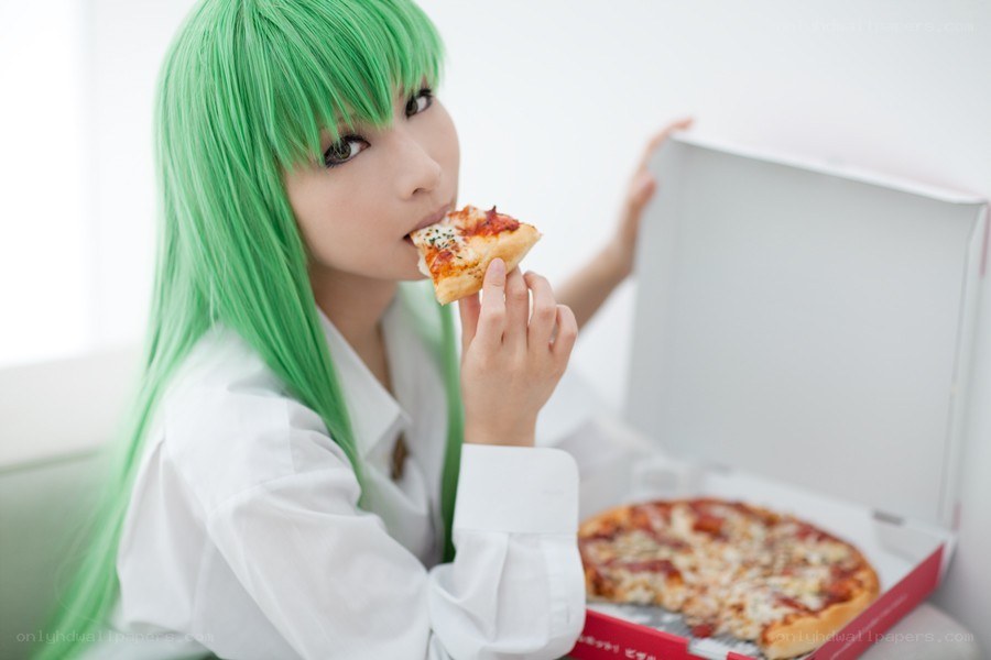 green-haired person eating pizza