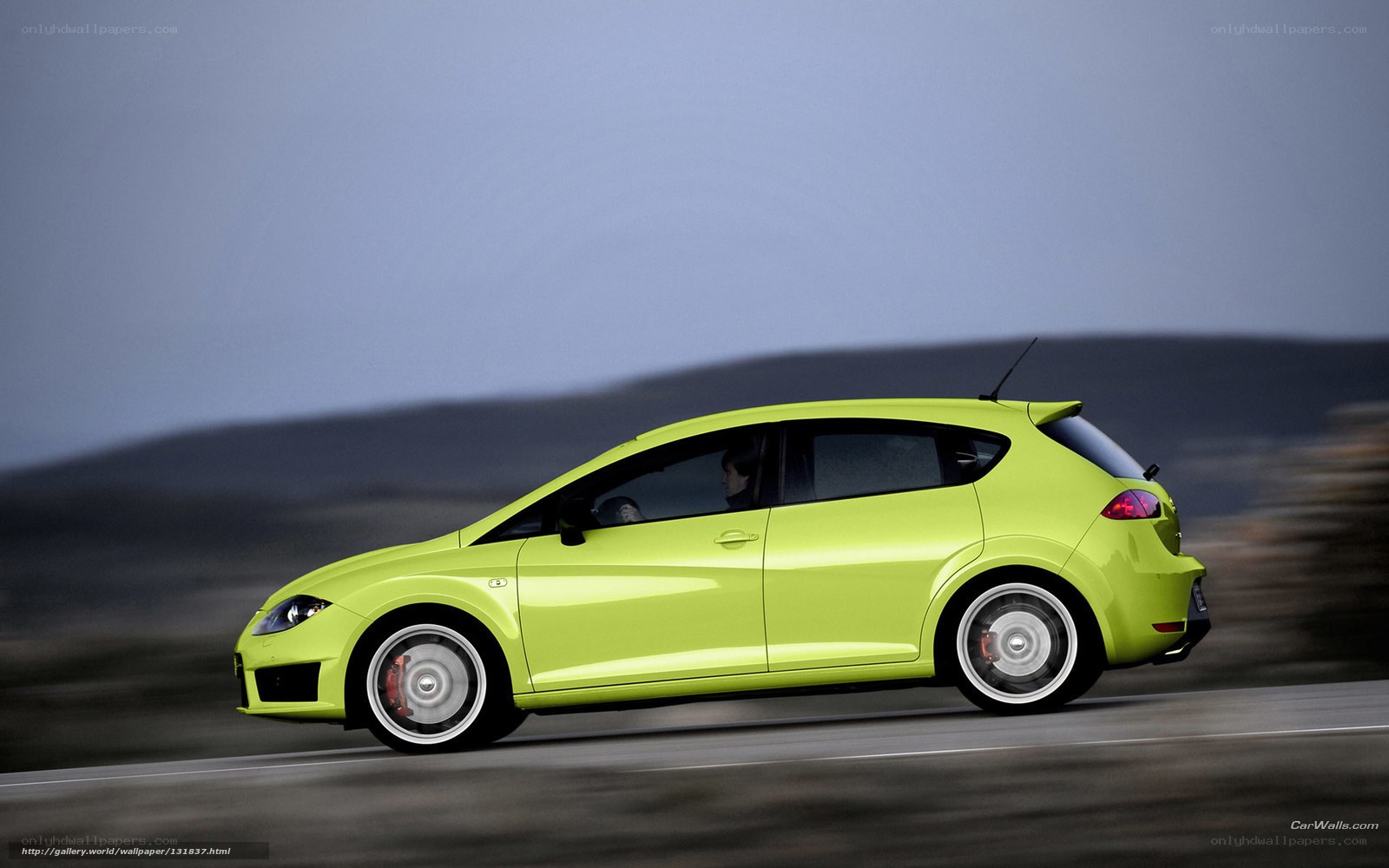 green hatchback car in motion
