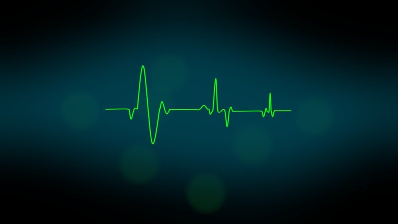 green heartbeat line on dark background