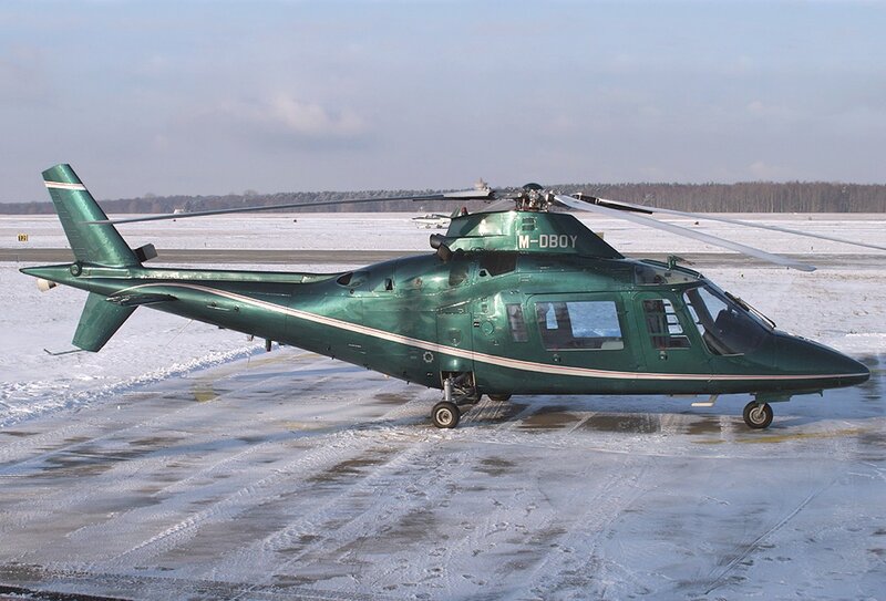 Green helicopter on snowy tarmac