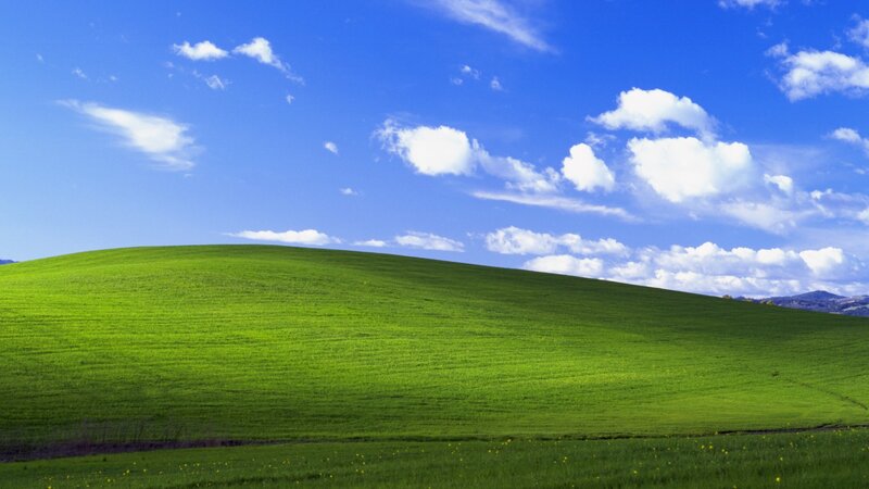 green hill under blue sky