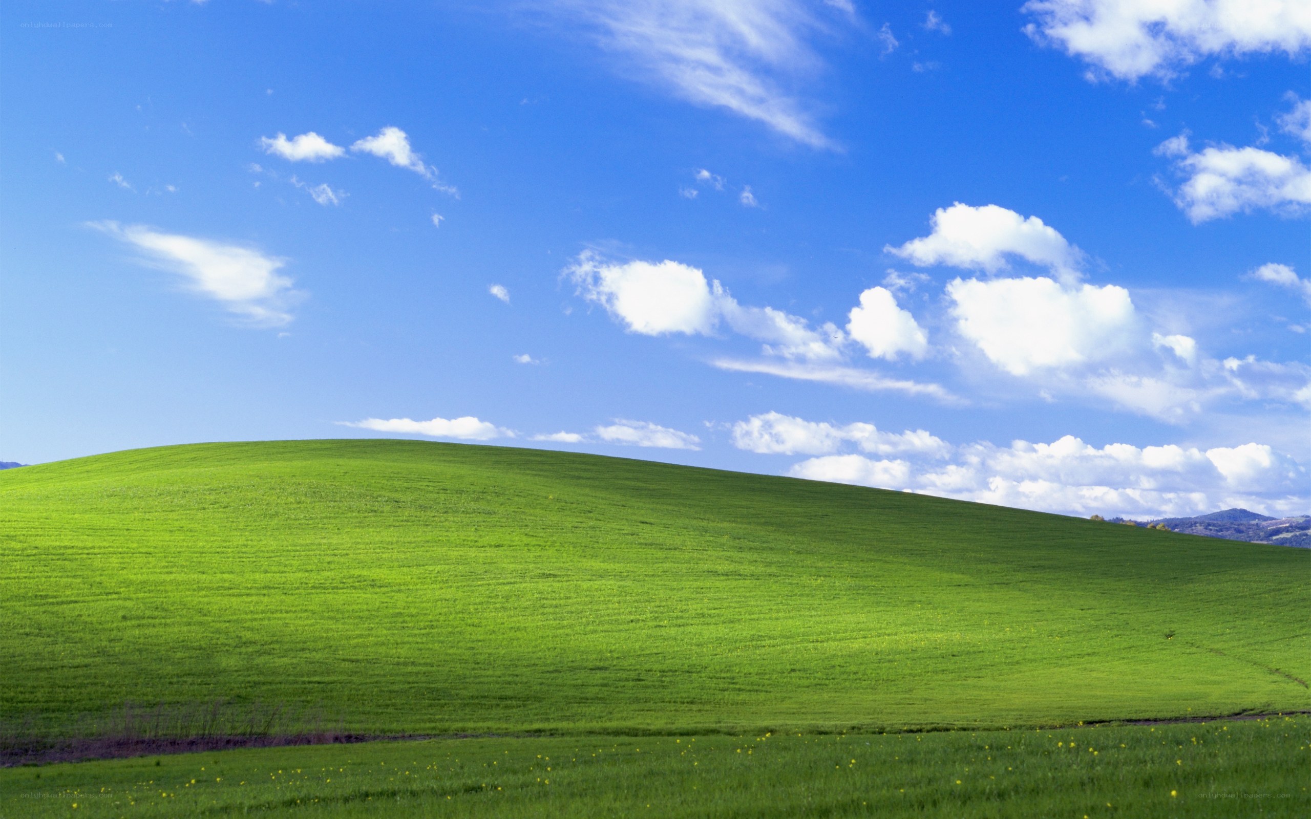 Green hill under blue sky