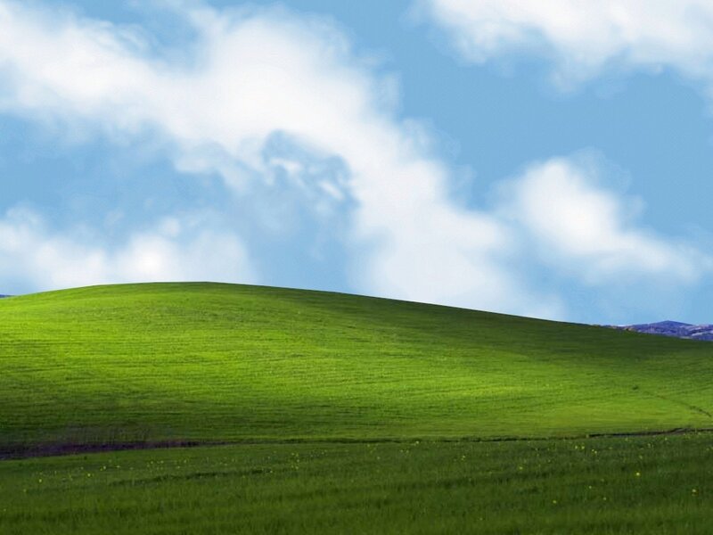 green hill under blue sky