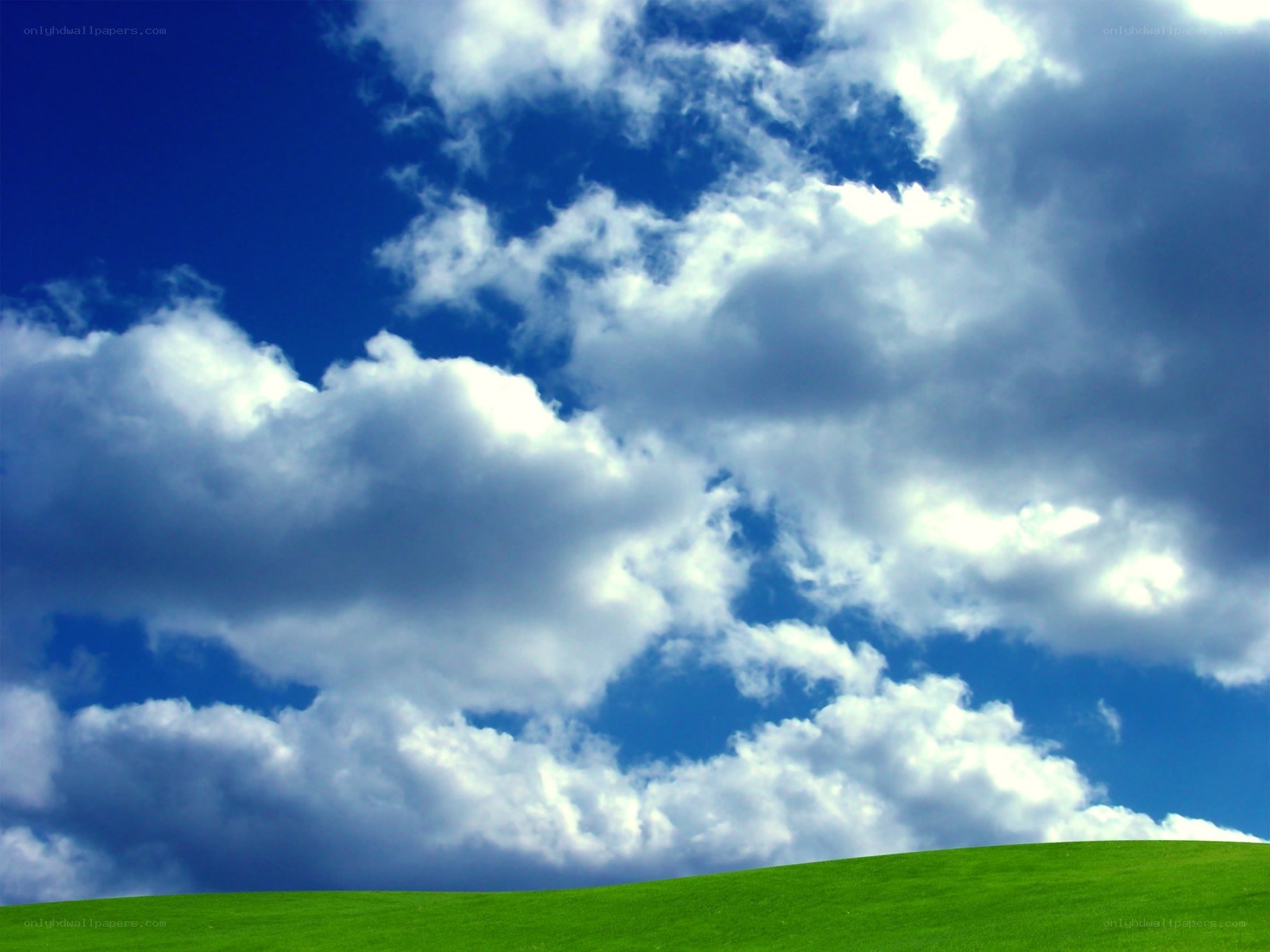 Green hill under blue sky
