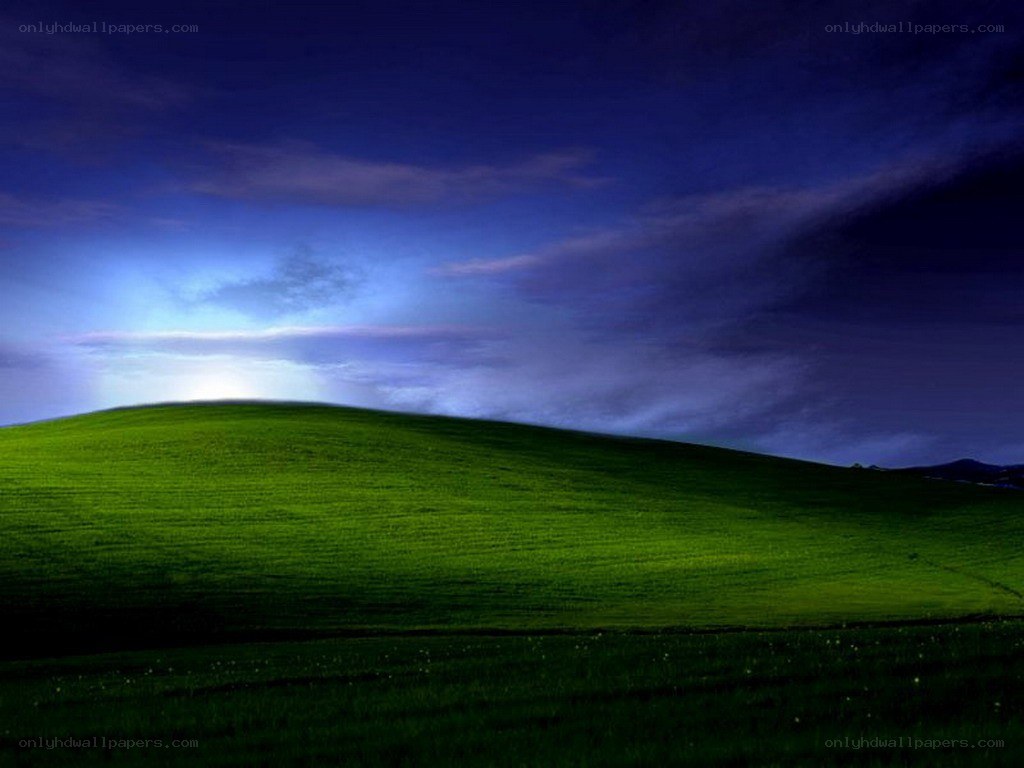 Green hill under blue sky
