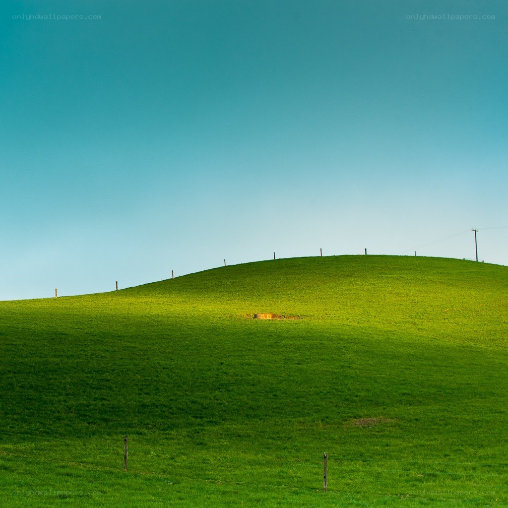 Green hill under blue sky