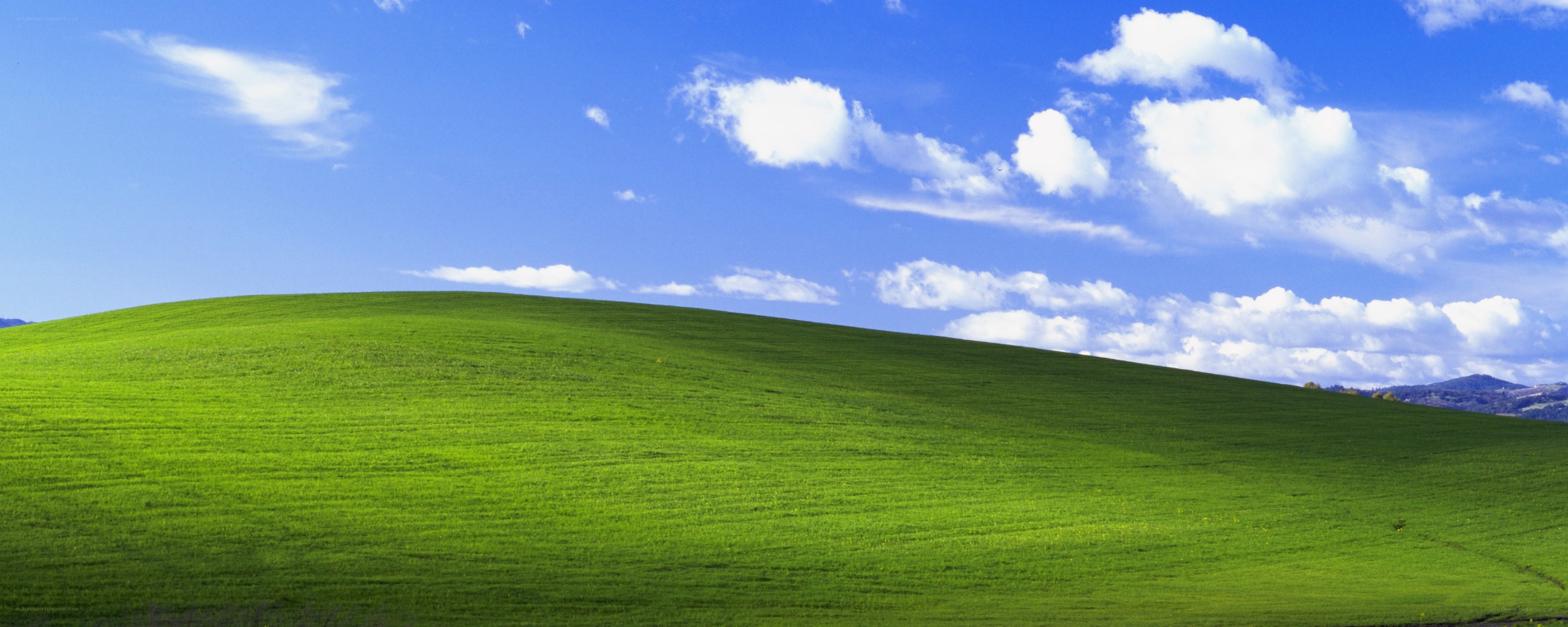 green hill under blue sky