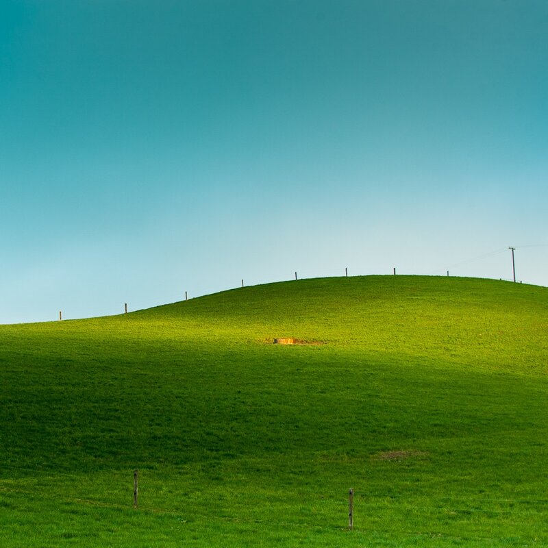 Green Hill under Blue Sky — Serene, Afternoon, Photograph, Fence Posts