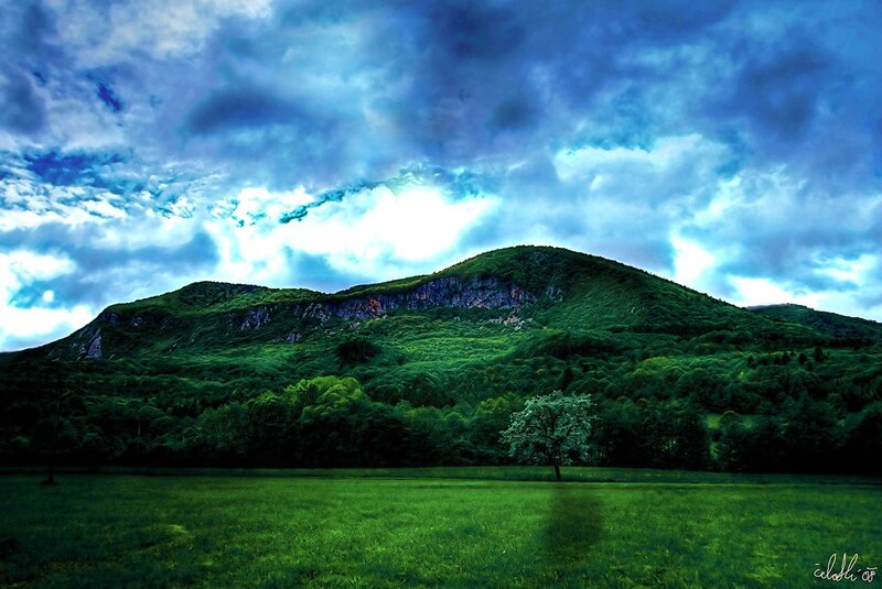 Green Hill Under Stormy Sky