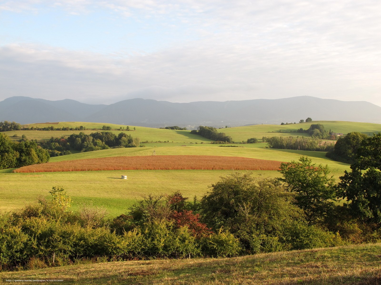 Green hills and distant mountains