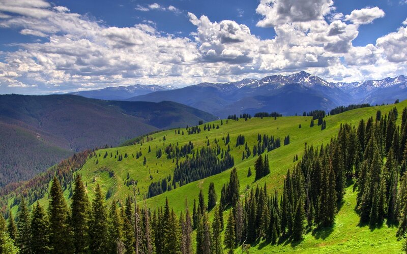 Green hills and snow-capped mountains