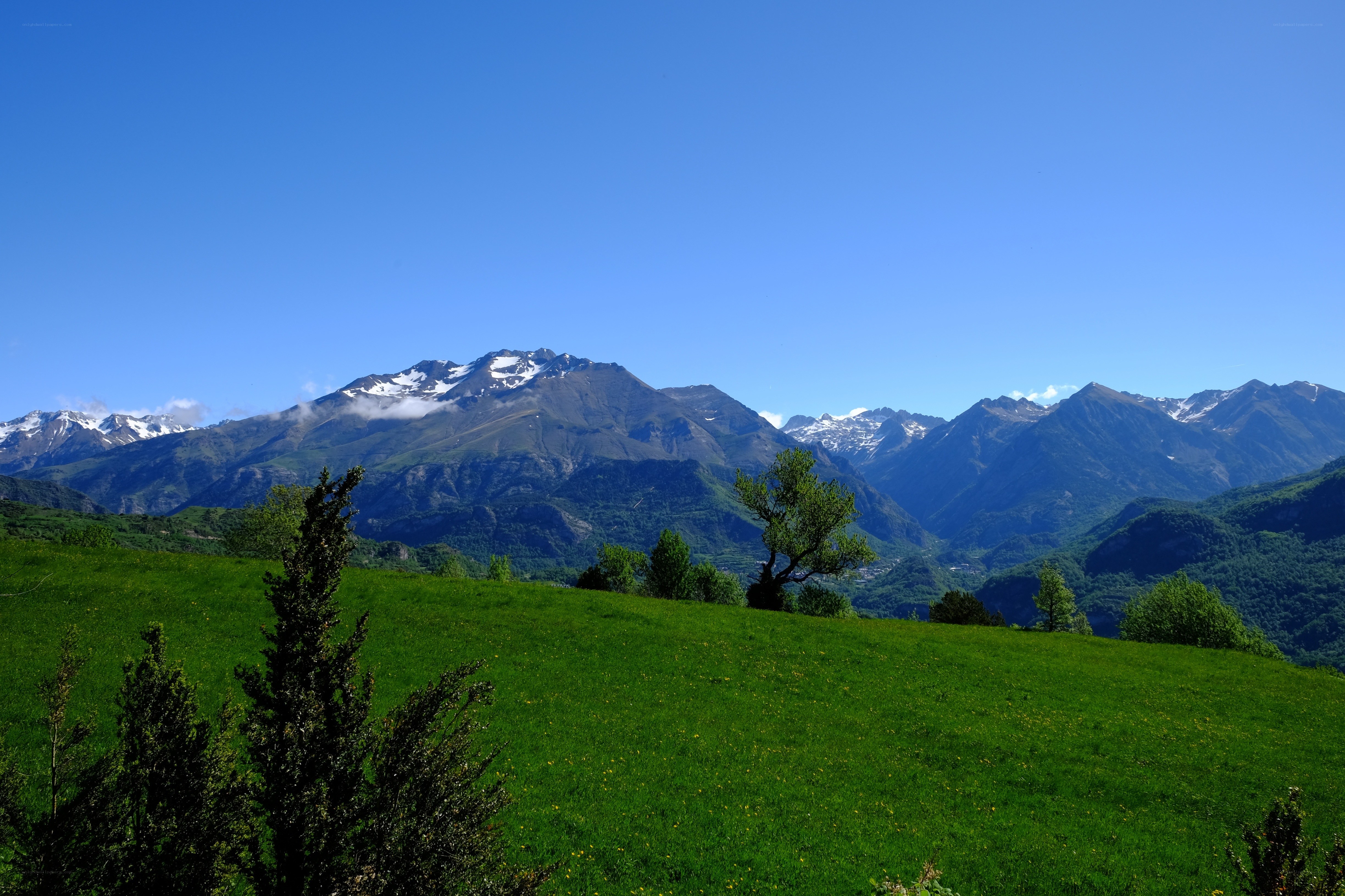Green hills and snow-capped mountains