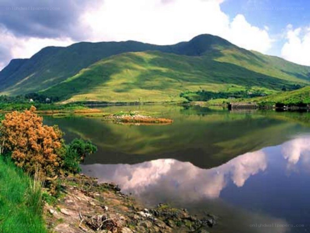 green hills reflected in lake