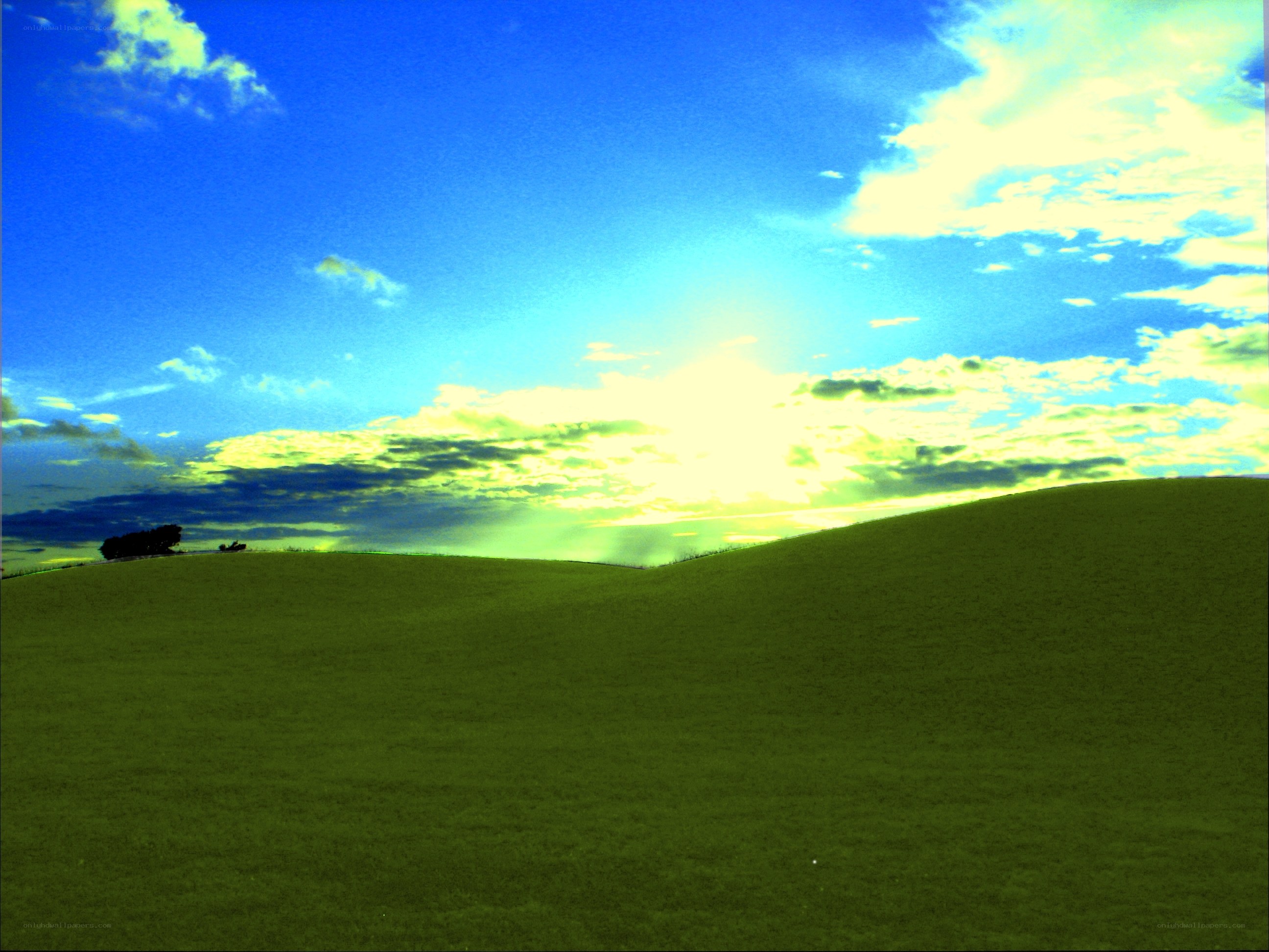 Green hills under a bright sky